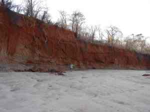 Walking by the red cliffs in the sandy river bed.